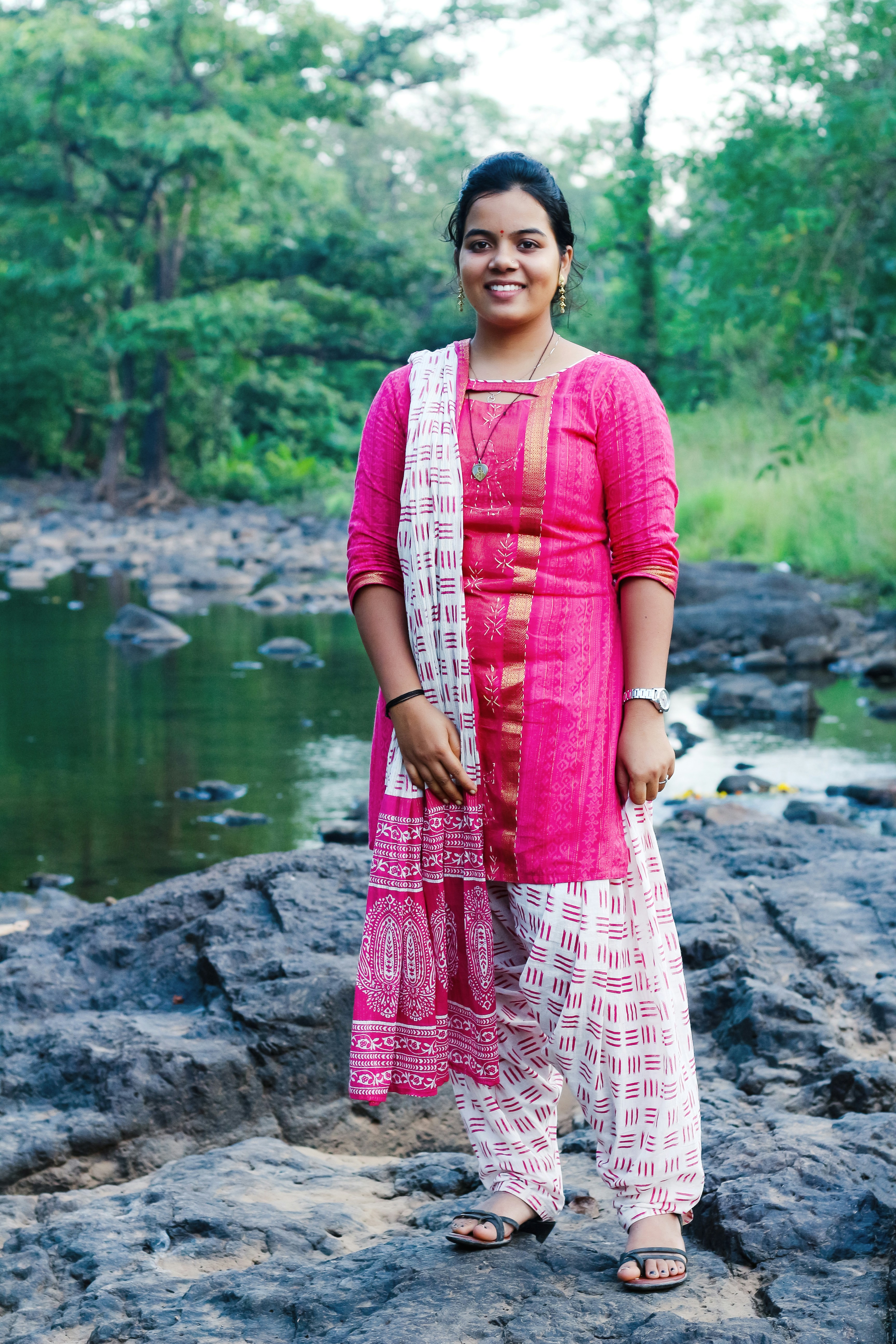 a woman standing on a rock next to a river