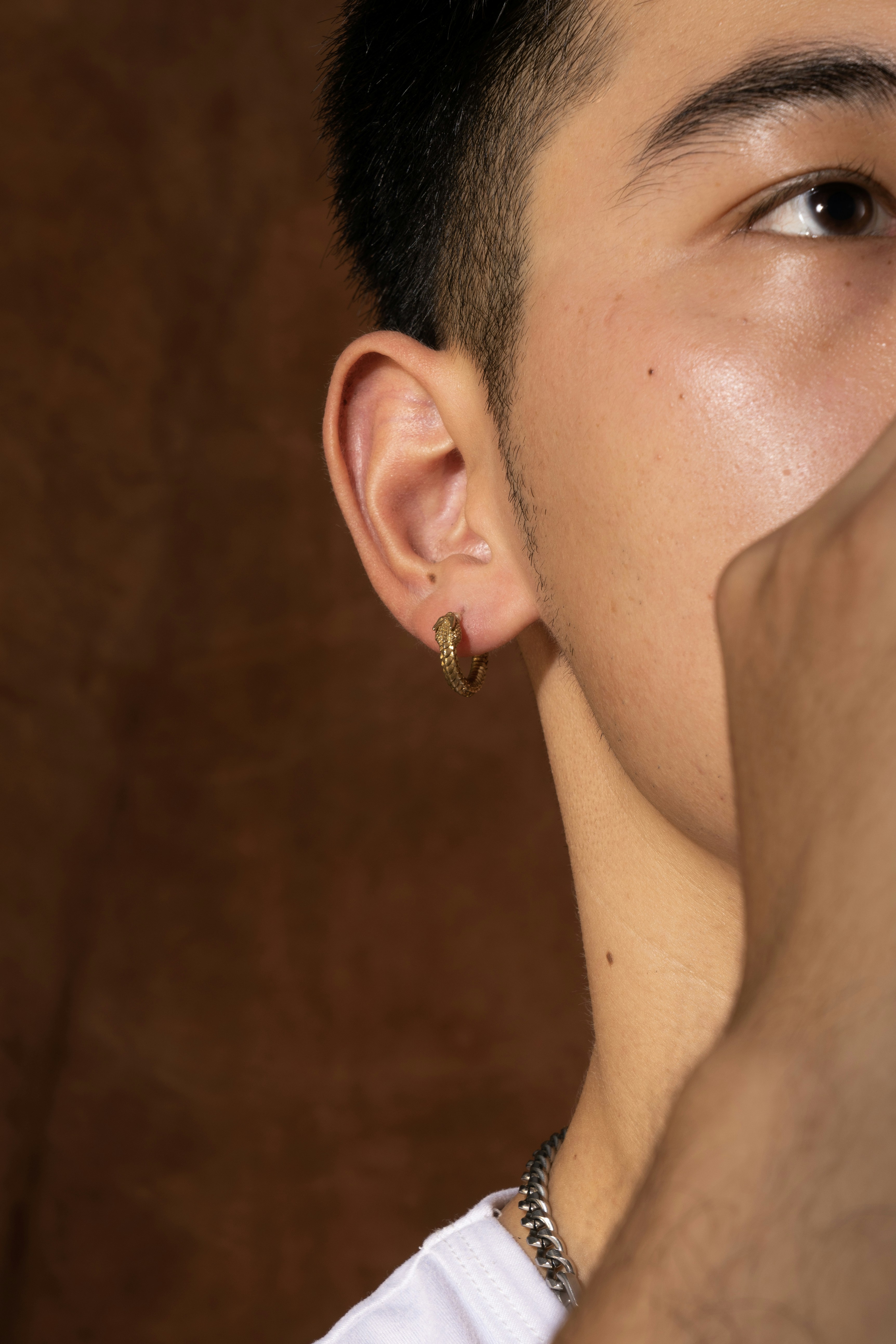 a man with a pair of earrings on his ear