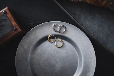 Vintage copper earrings displayed on a matte black stand highlighting their texture