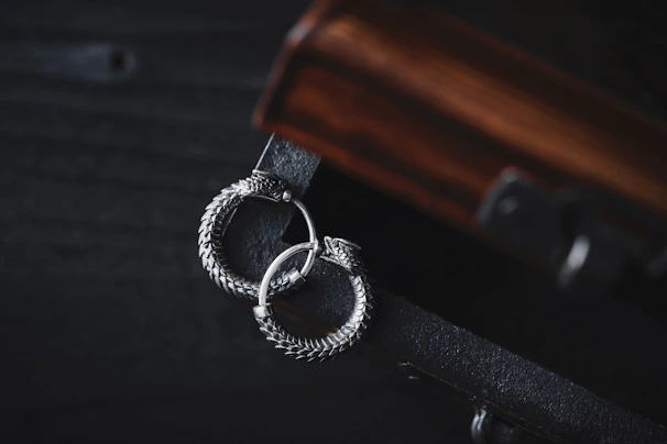 A pair of elegant silver earrings with intricate filigree details displayed on a marble surface.