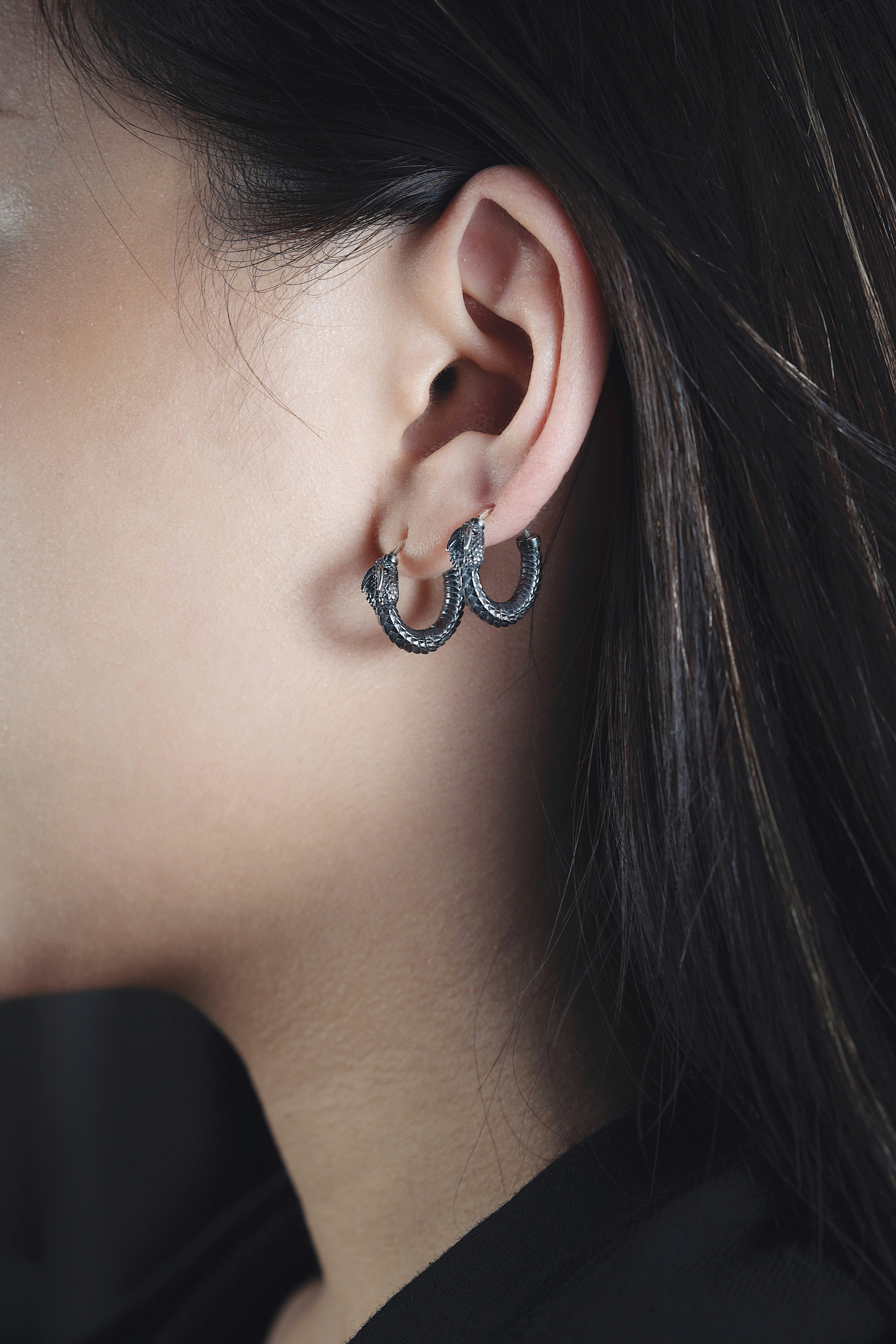 a close up of a person wearing a pair of earrings