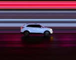 a white car driving down a street at night