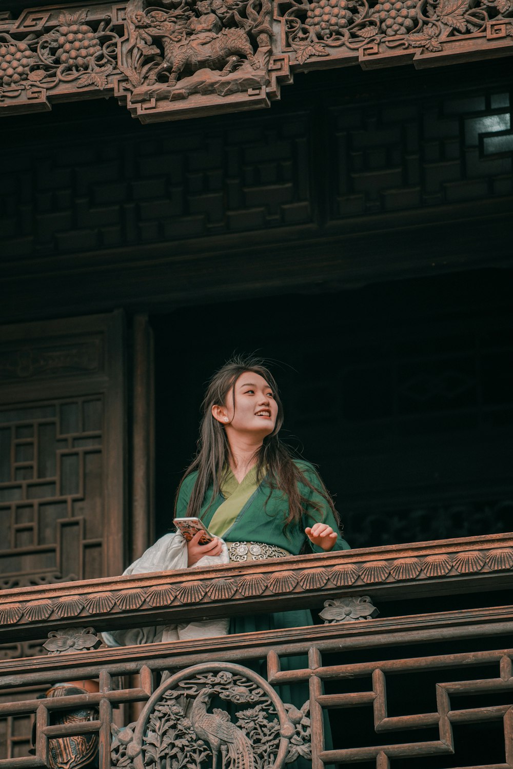 a woman standing on a balcony looking up