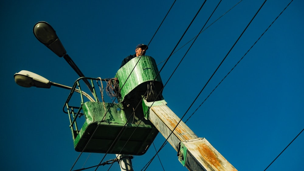 a man standing on top of a power pole