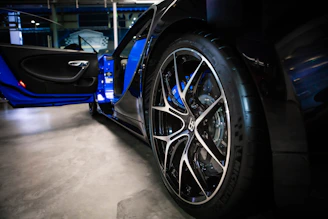 A set of premium car wheels displayed in a stylish showroom with elegant lighting.