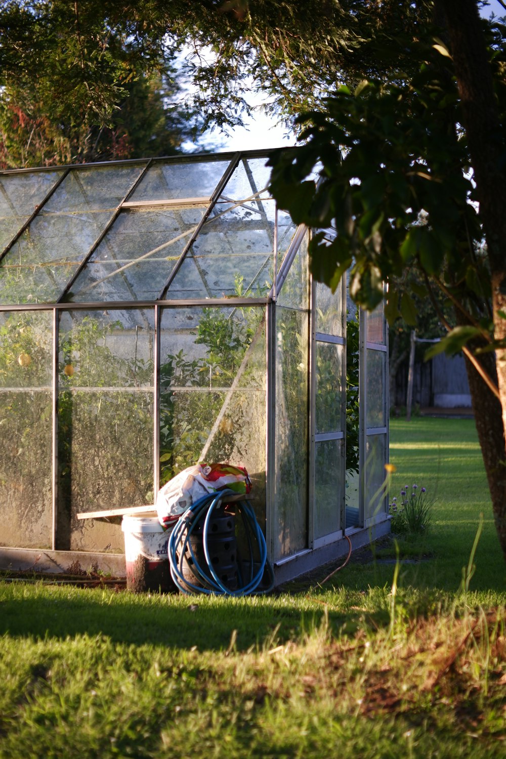 a small greenhouse with a hose attached to it