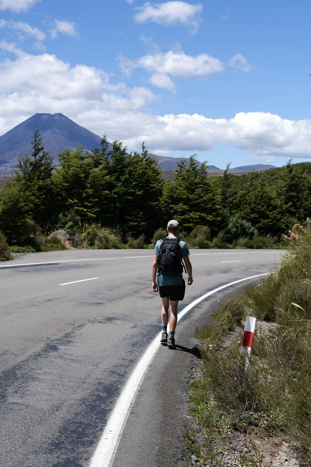 a man with a backpack walking down the road