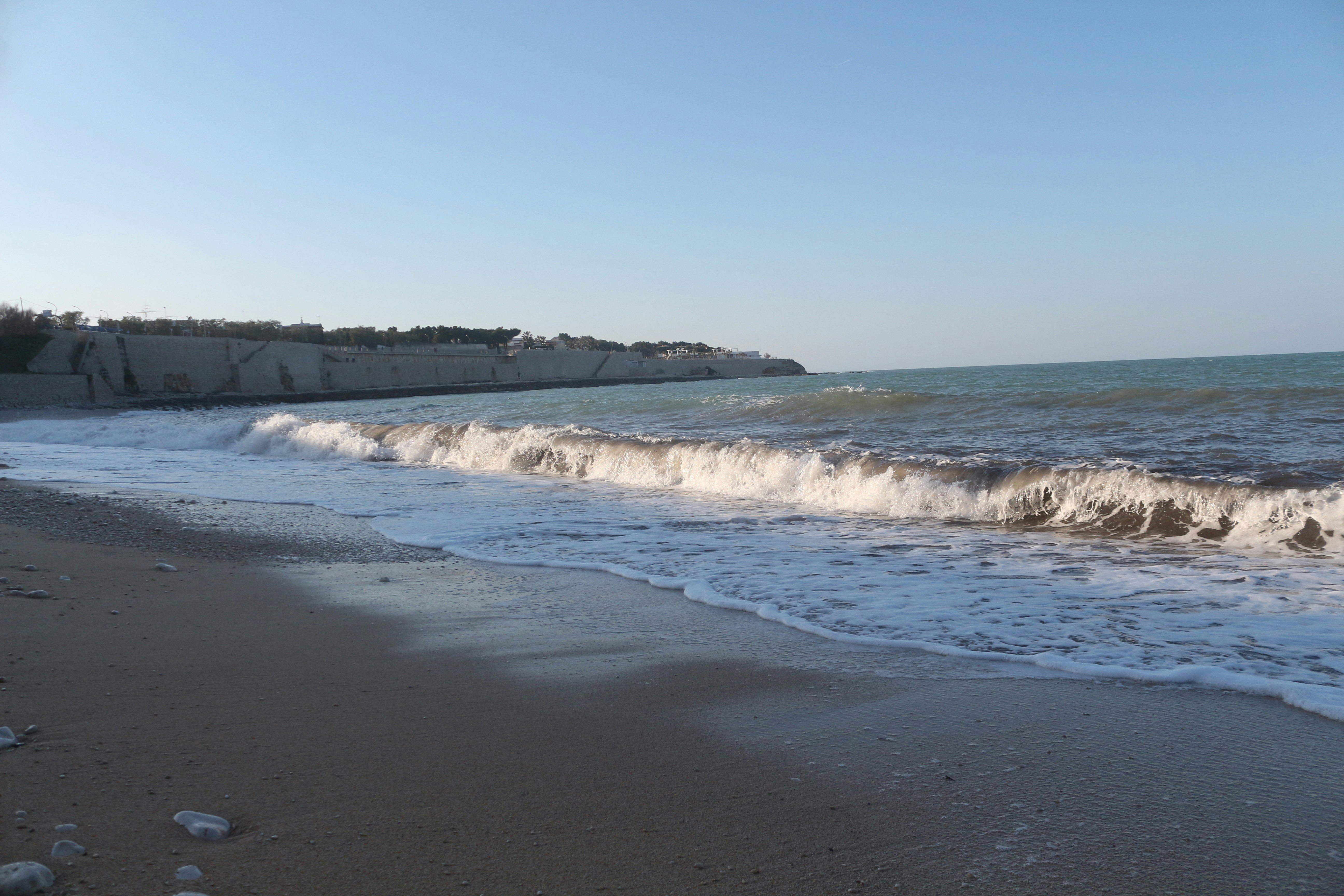 a sandy beach with waves coming in to shore