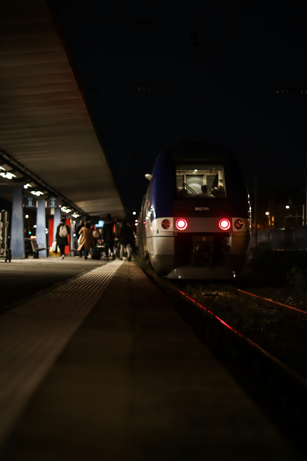 a train is pulling into a station at night