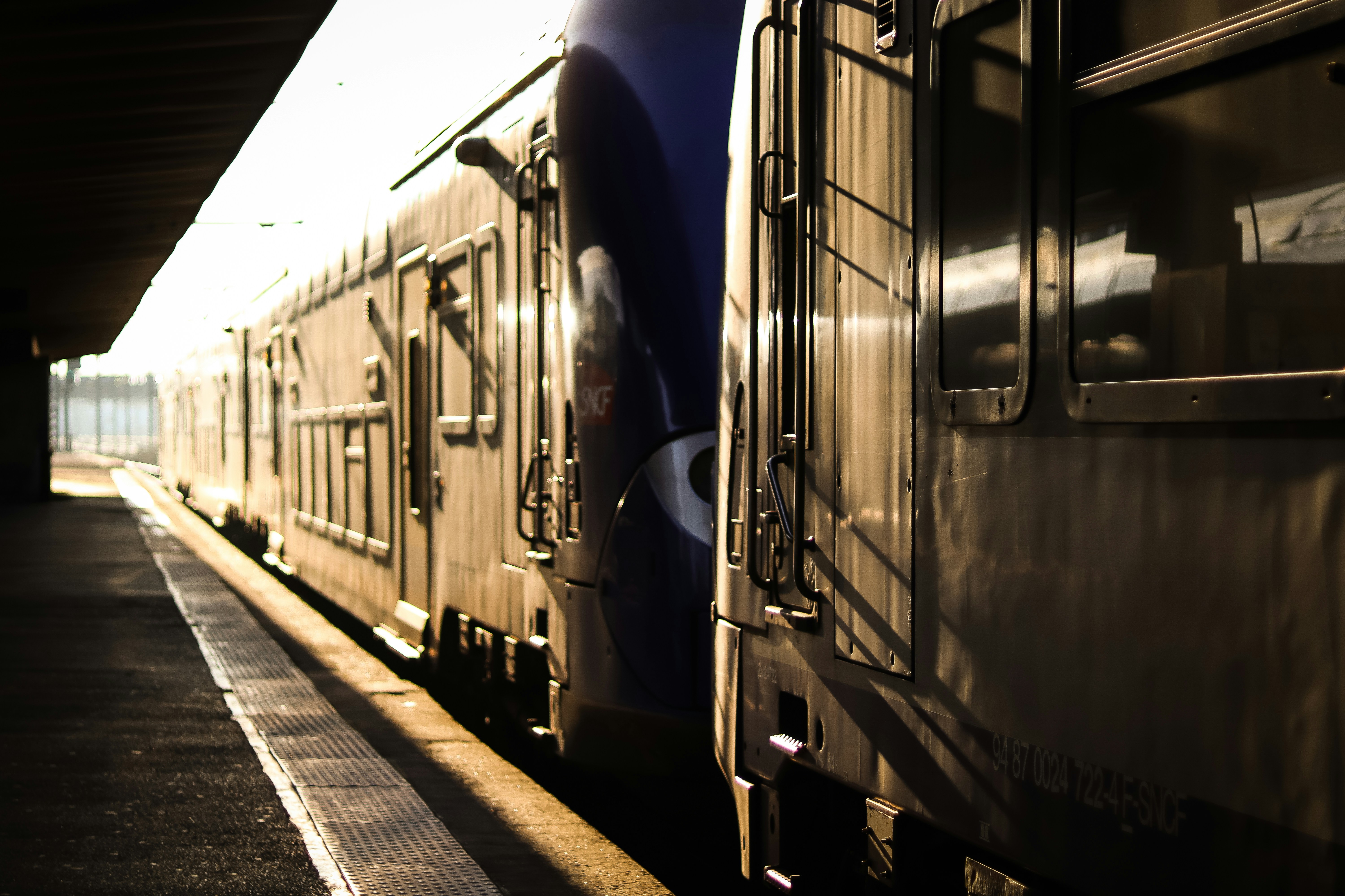 a train parked at a train station next to a platform, 
