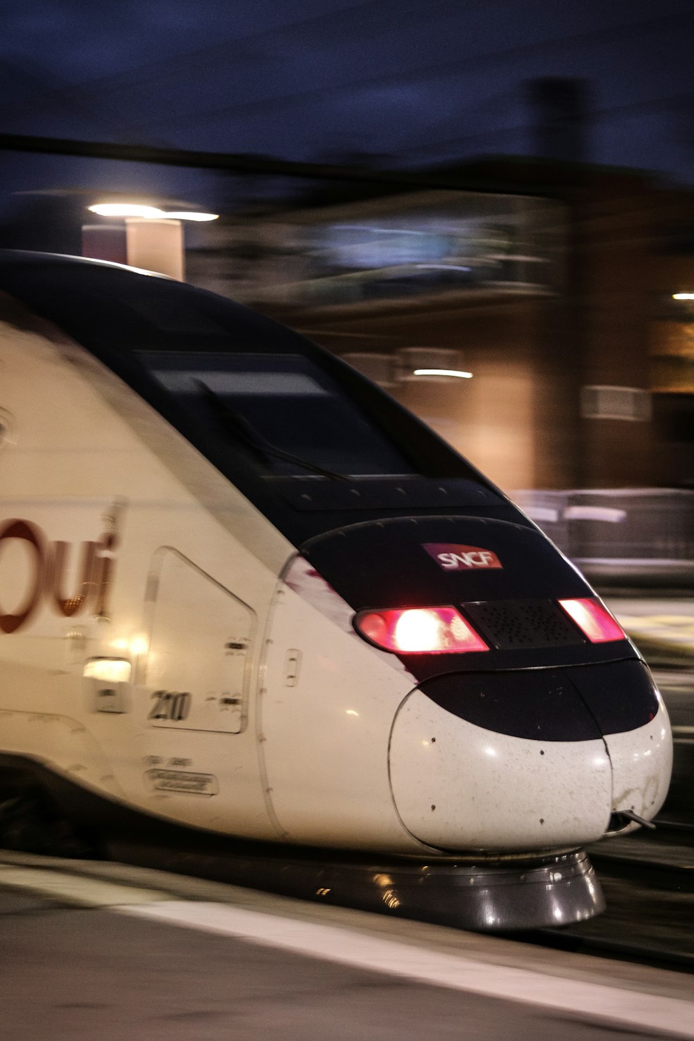 a white train traveling down train tracks at night