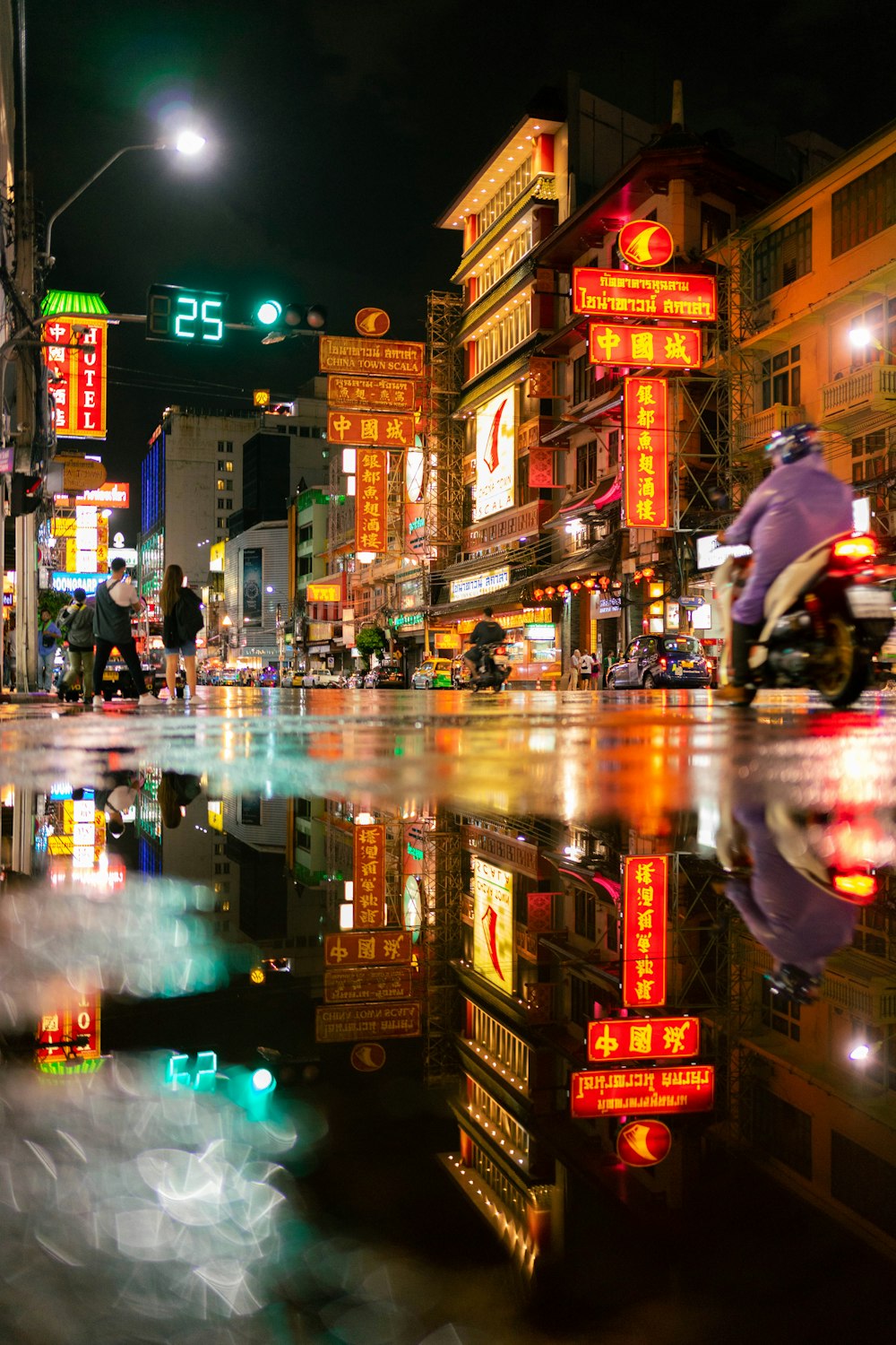 a person riding a motorcycle on a city street at night