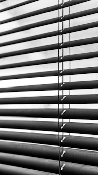 a black and white photo of a window with blinds