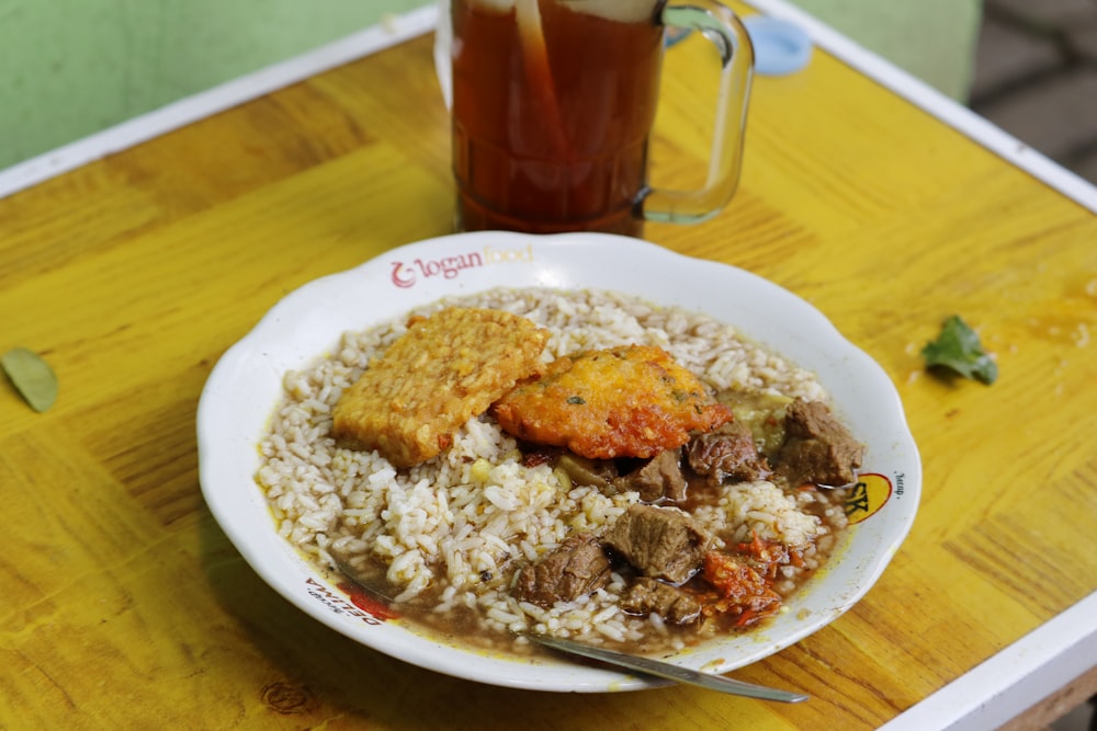 a bowl of food and a drink on a table