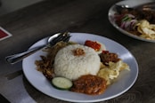 a white plate topped with rice and meat