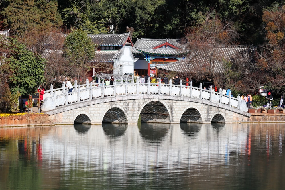 a bridge over a body of water with people standing on it