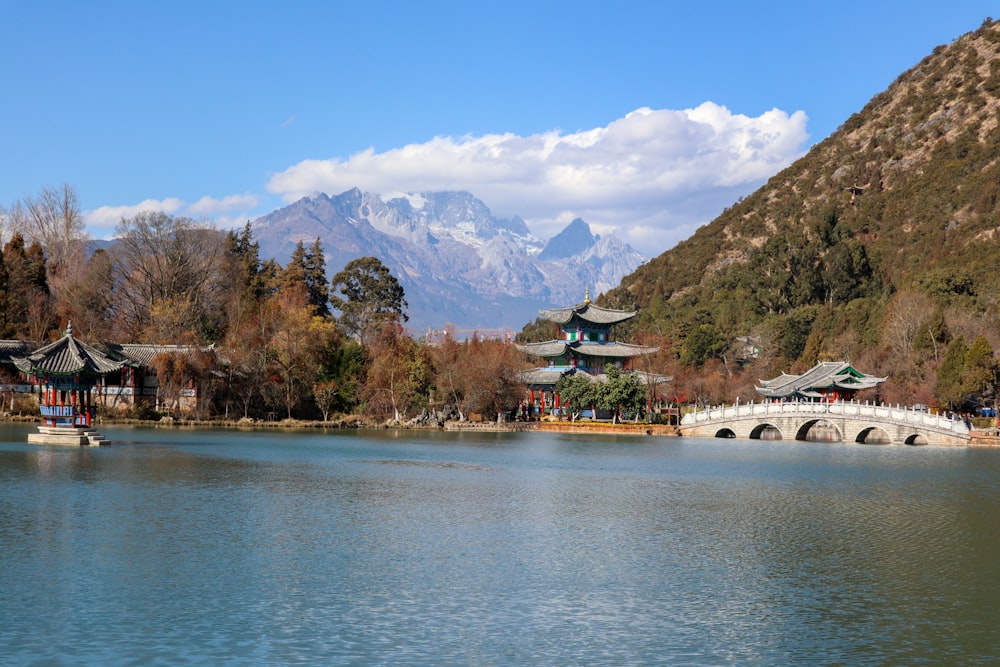 a lake with a bridge and mountains in the background