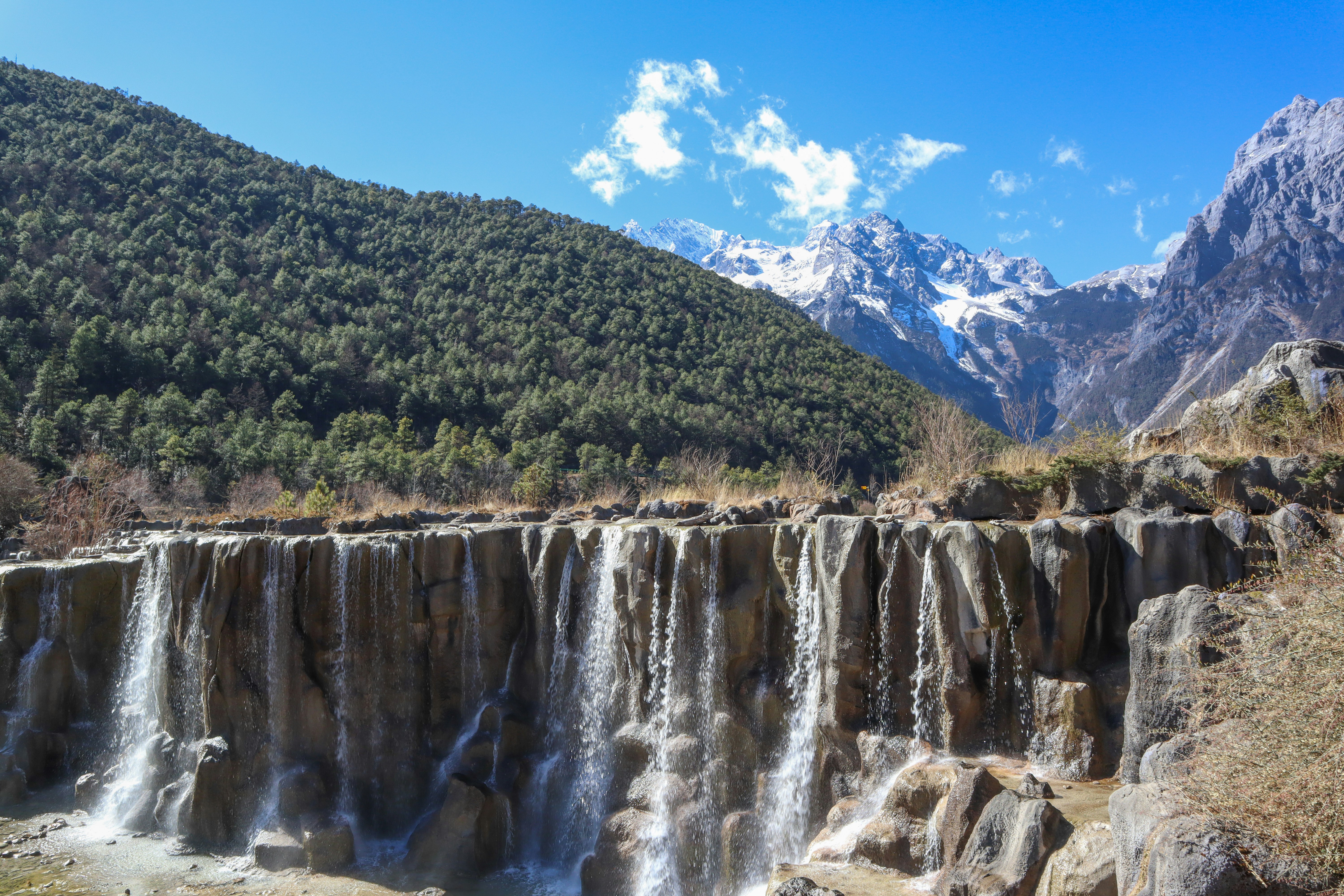 a large waterfall with a mountain in the background