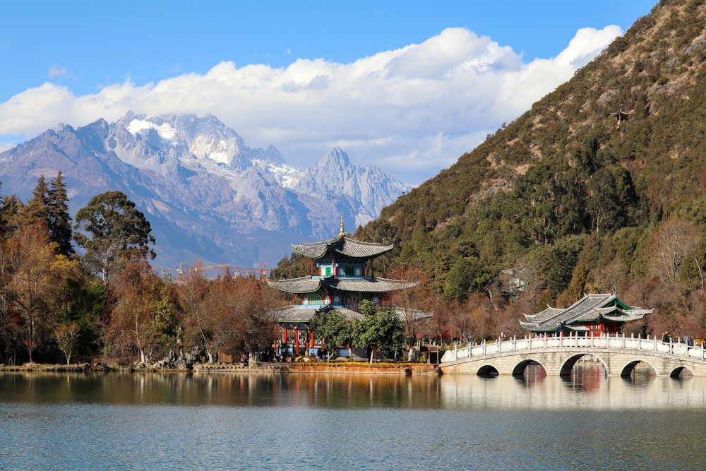 a bridge over a lake with mountains in the background