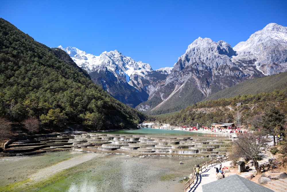 a scenic view of a mountain range with a lake in the foreground