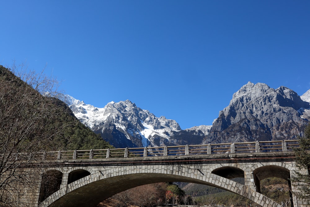 a bridge over a river with mountains in the background