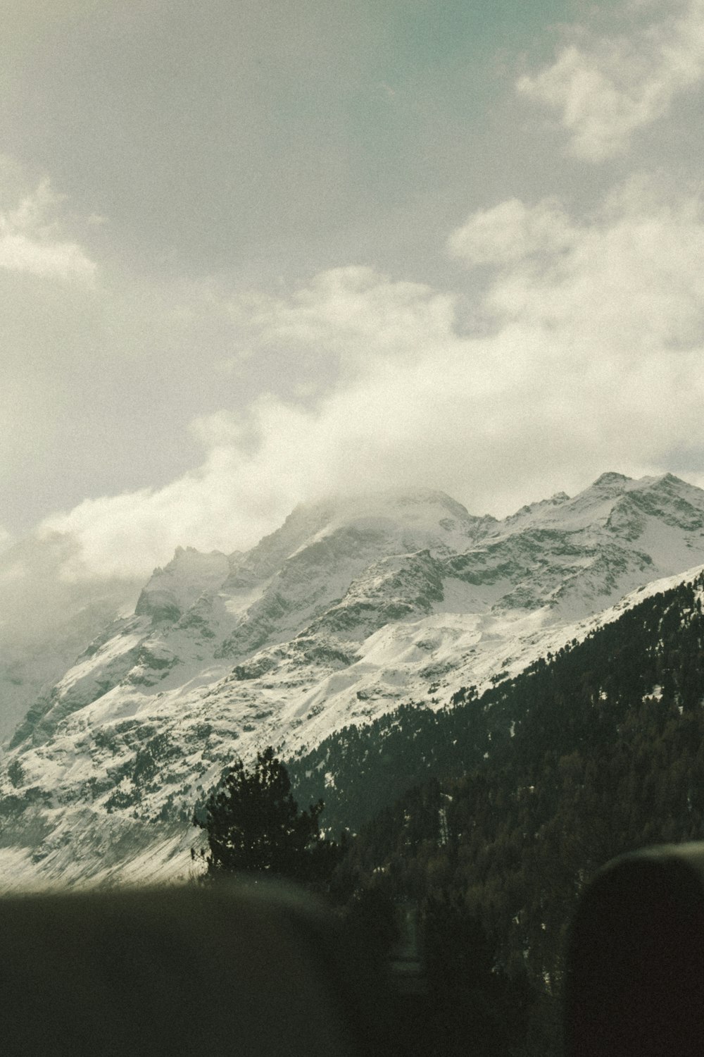 uma vista de uma montanha nevada de uma janela de trem