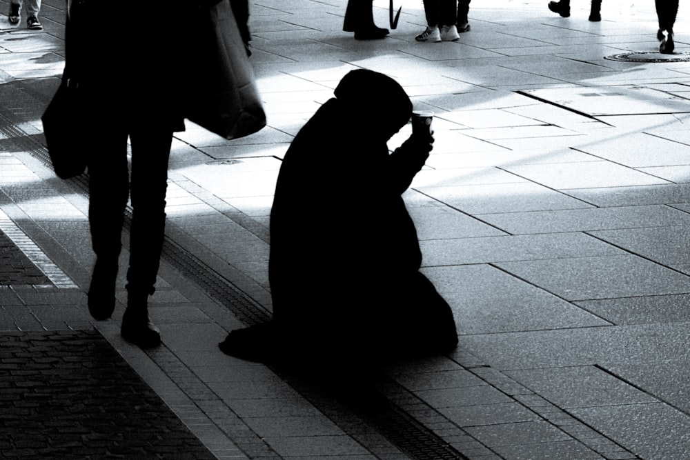 a person sitting on the ground using a cell phone