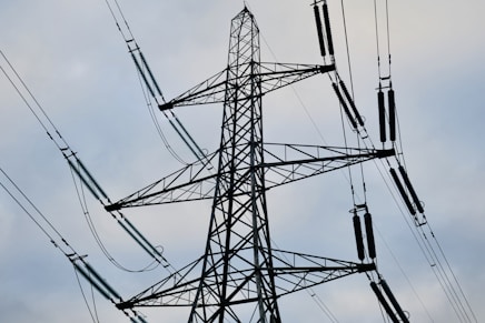 a high voltage power line against a cloudy sky