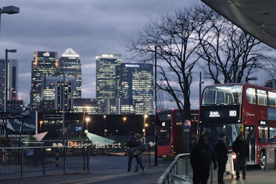 A sleek, modern skyline of London’s financial district at dusk, glowing with golden lights.