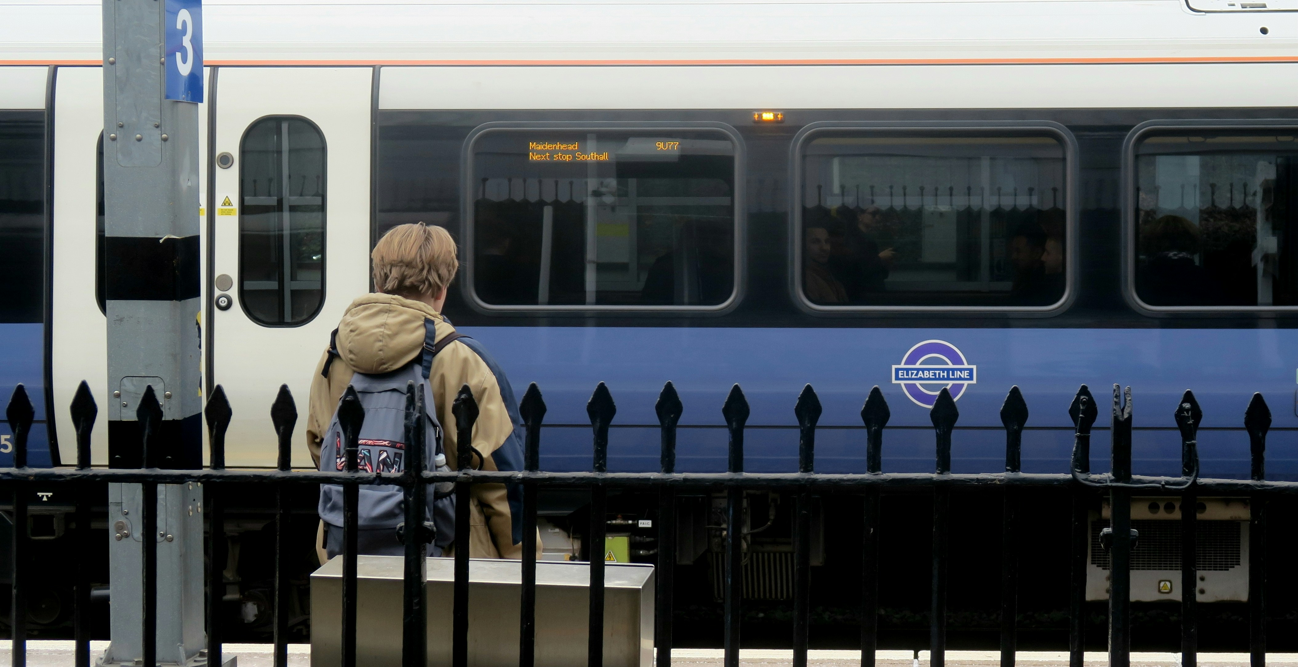 Una mujer parada en un andén junto a un tren