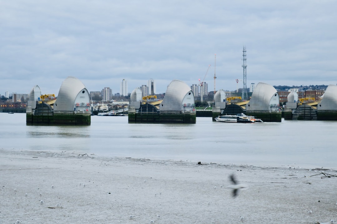 a large body of water with a bridge in the background, Thames Barrier