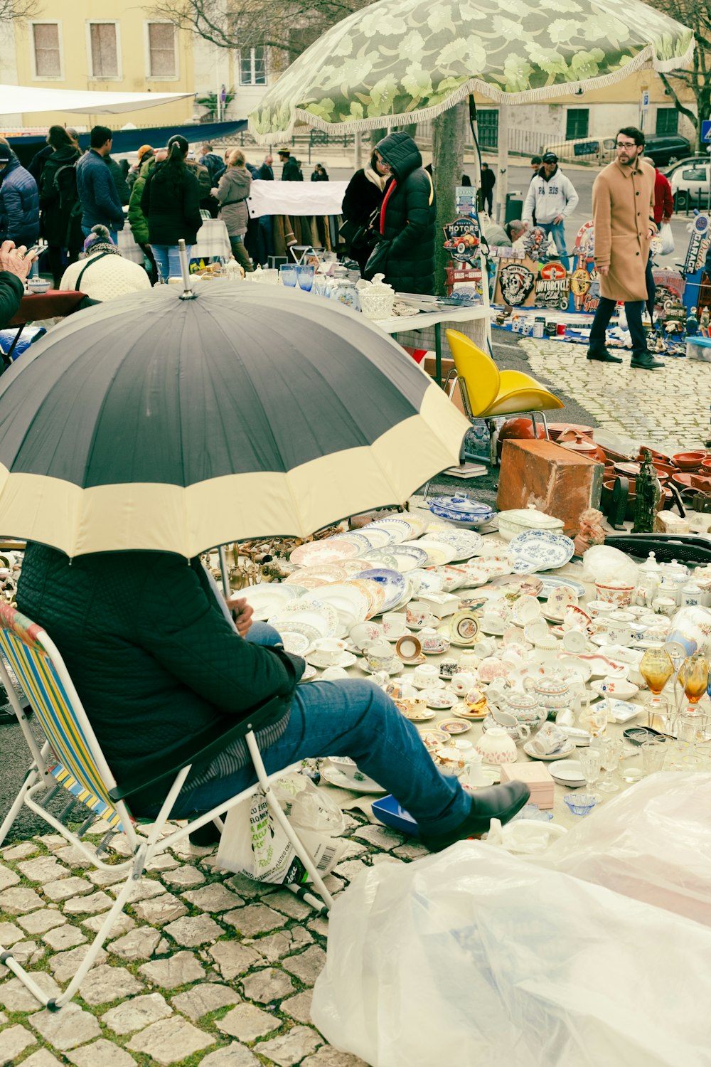 a man sitting in a chair under an umbrella