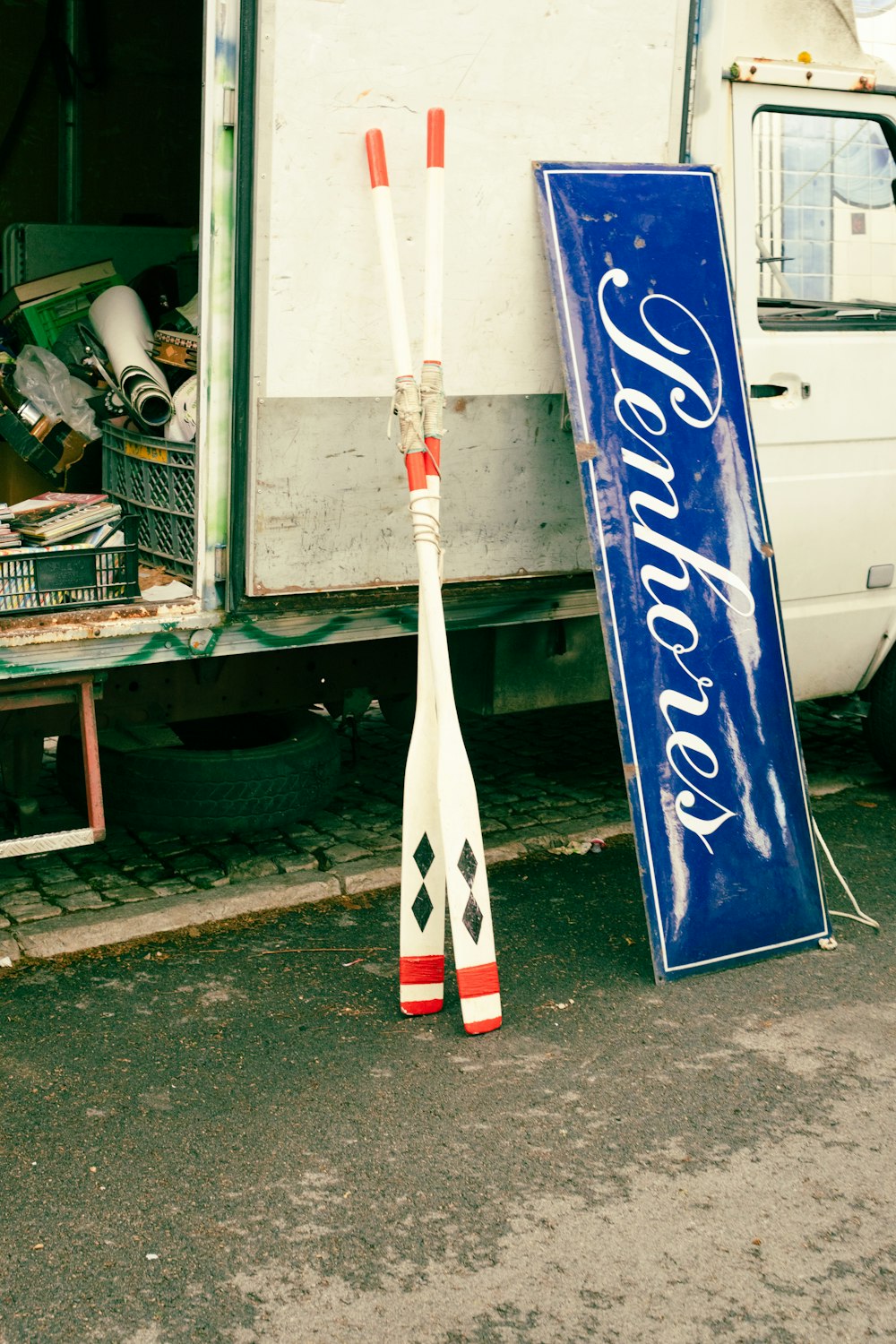 a street sign and two baseball bats in front of a truck