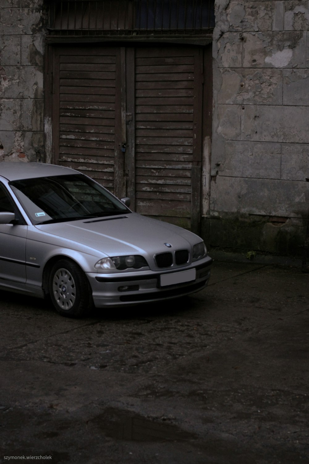 a silver car parked in front of a building