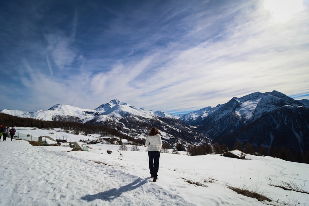 Una mujer parada en la cima de una pendiente cubierta de nieve