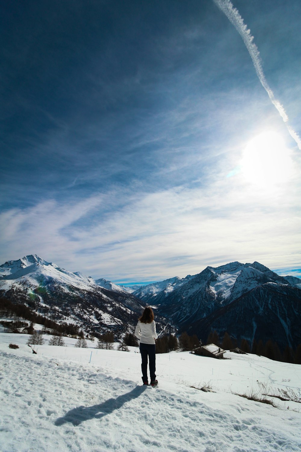 a woman standing on top of a snow covered slope