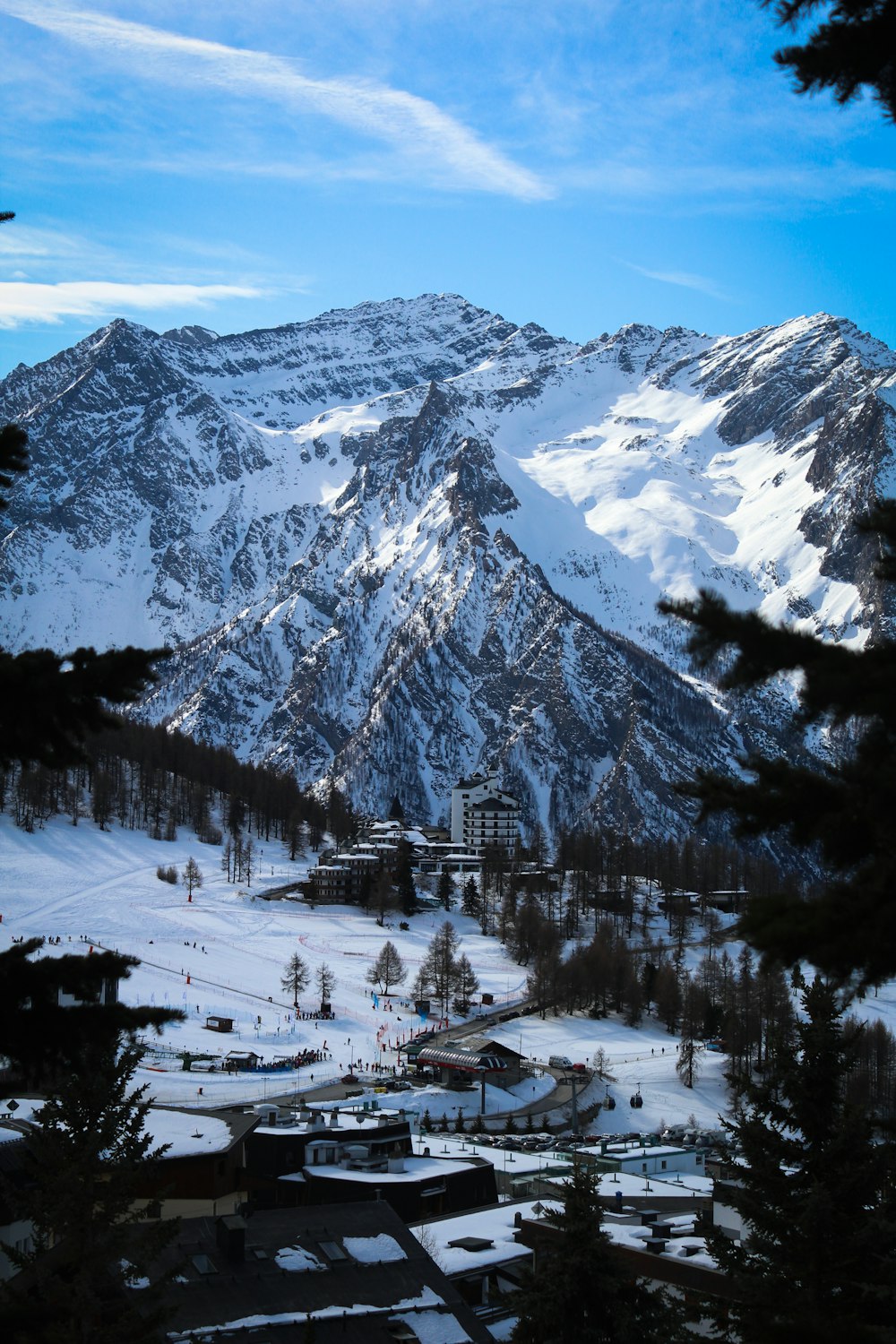 uma montanha coberta de neve com uma loja de esqui em primeiro plano