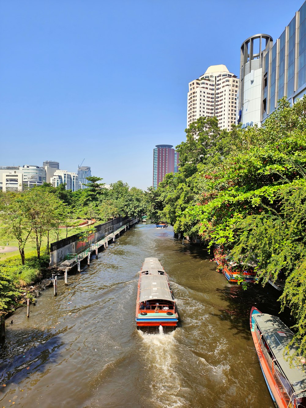 a boat traveling down a river next to tall buildings