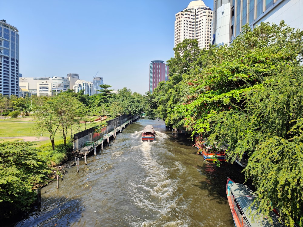 a boat traveling down a river next to tall buildings