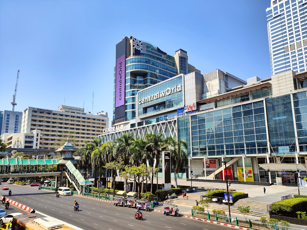 a busy city street with tall buildings and palm trees