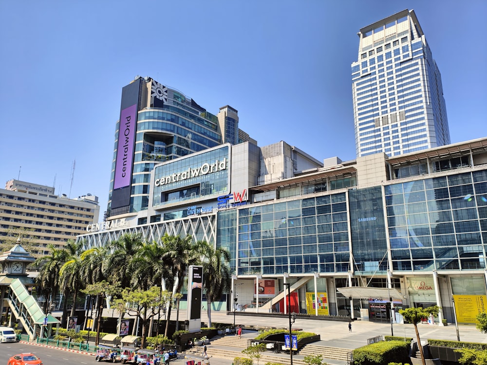 a large building with a lot of windows and palm trees in front of it