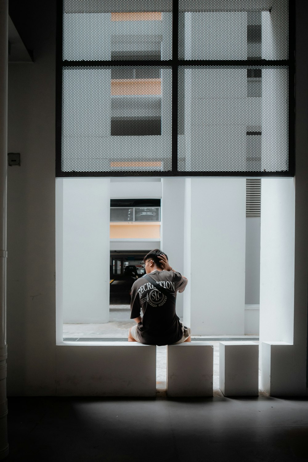 a person sitting on a ledge in front of a window