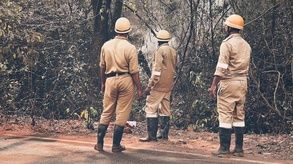 a group of men standing on the side of a road