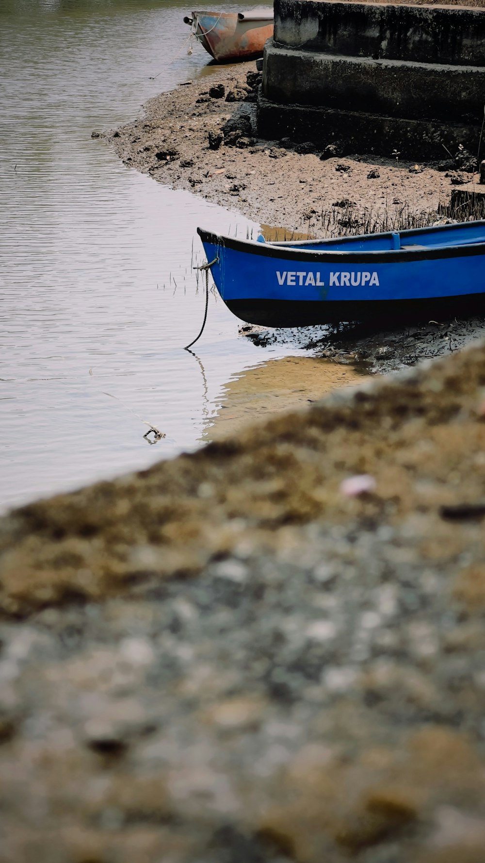 a small blue boat sitting on top of a body of water