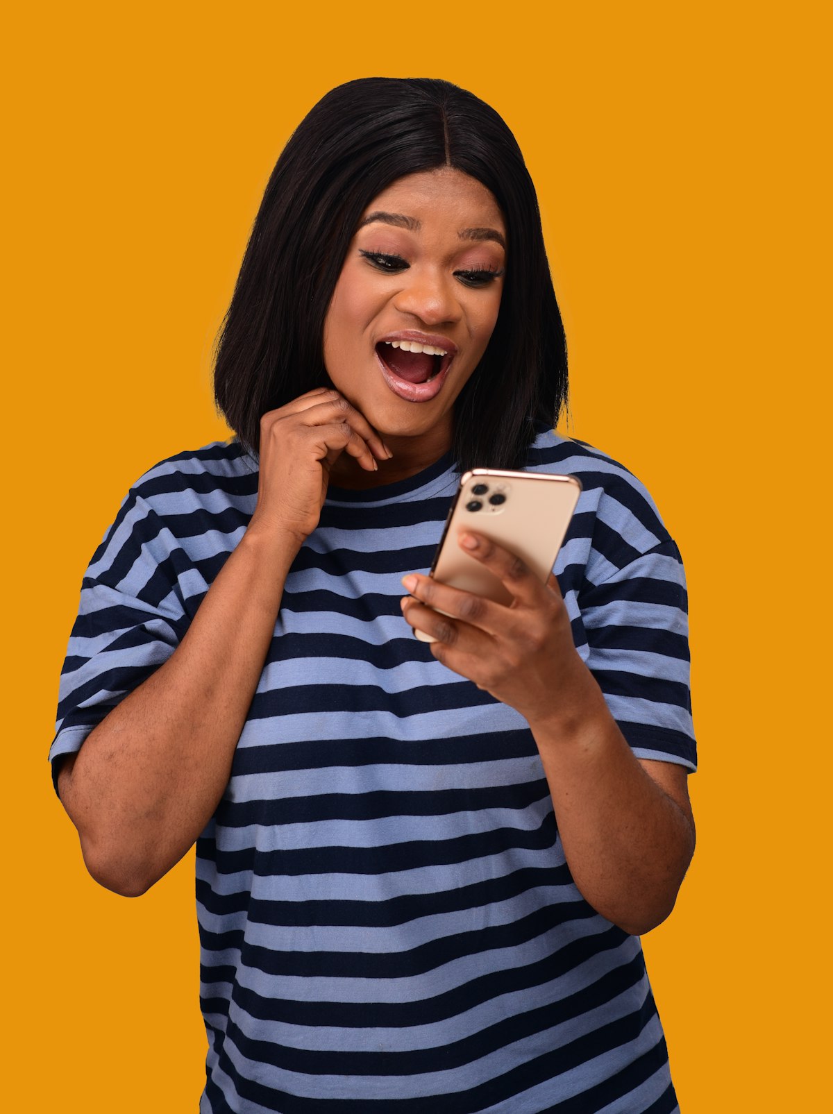 A woman smiling at her phone in a marigold studio
