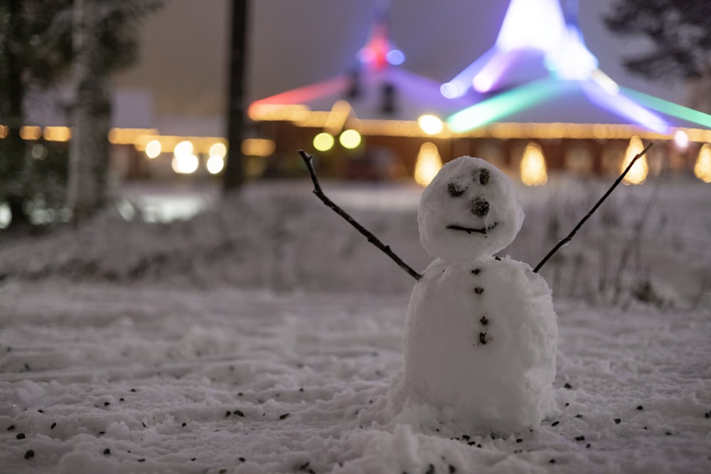 a snowman is standing in the snow in front of a building