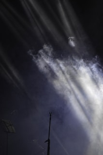 A shadowy microphone surrounded by flickering candlelight and gothic metal band posters.