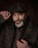 a man with a beard wearing a hat and holding a pipe