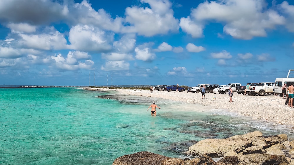 a group of people standing on top of a sandy beach