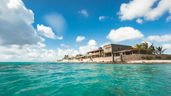 A house sitting on top of a sandy beach next to the ocean — Bonaire, Bonaire